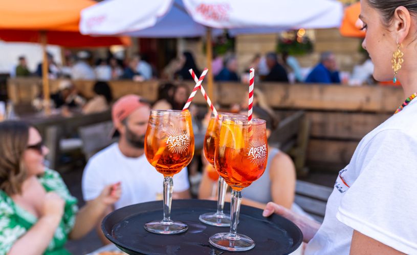 Waitress carrying Aperol Spritz